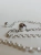 Sterling silver chain necklace with amber-inlaid sphere, close-up