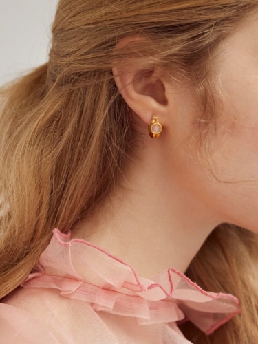 Gold-plated hoop earrings with mountain crystal worn on the ear