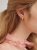 Gold-plated hoop earrings with mountain crystal worn on the ear